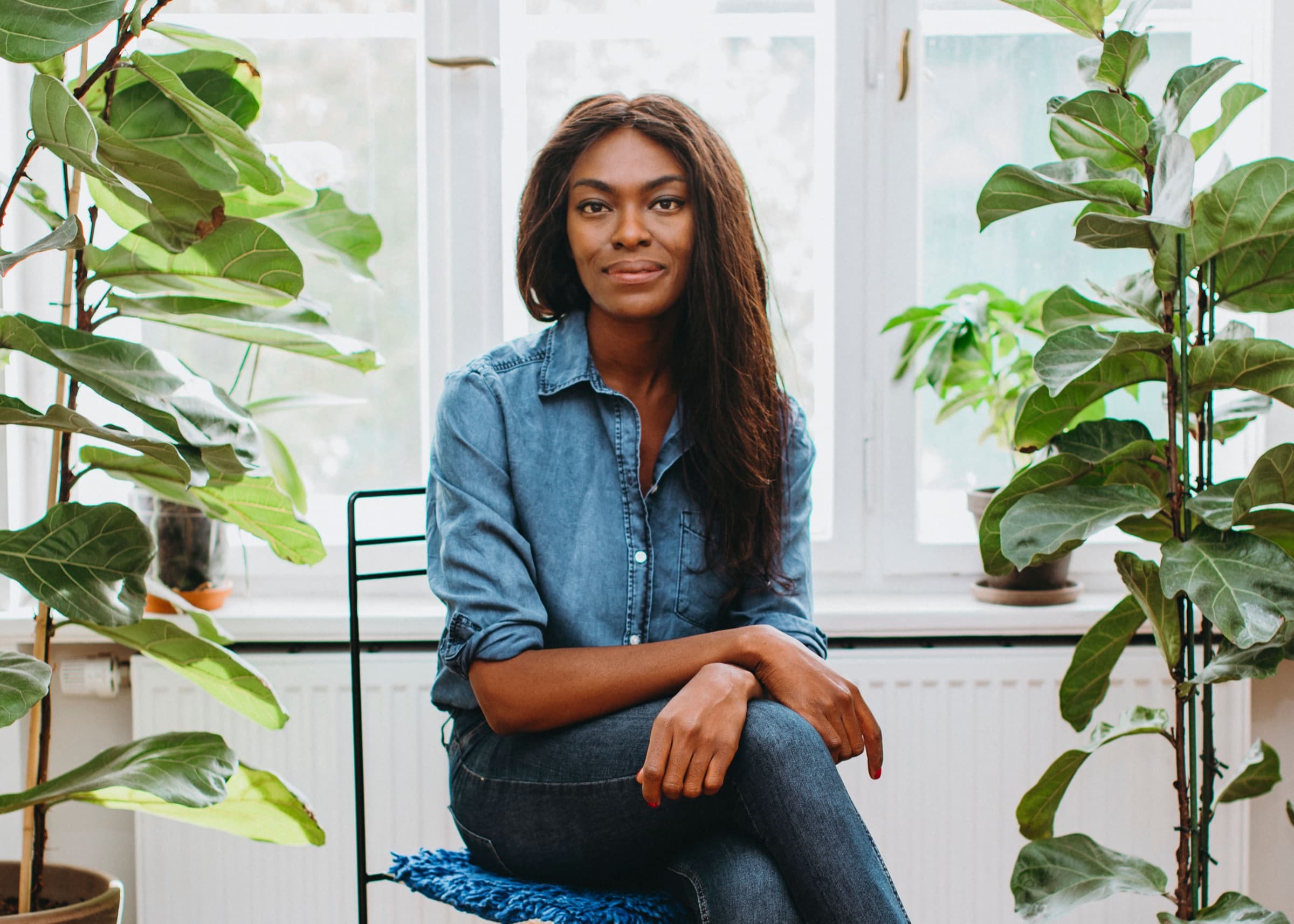 Portrait von Deborah Choi, Gastgeberin der Altbau Location Berlin, umgeben von Zimmerpflanzen